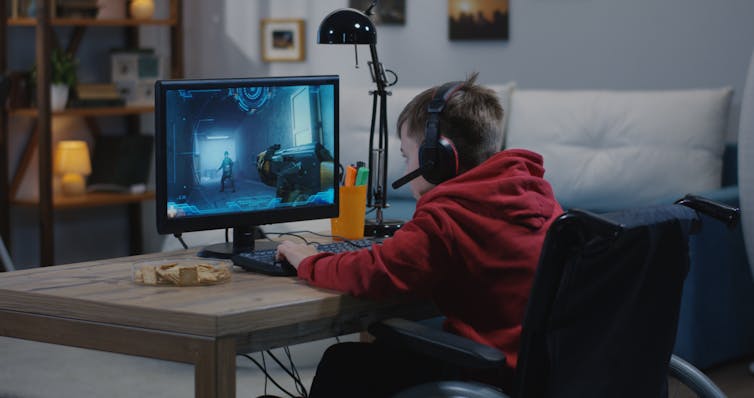 Boy with wheelchair gaming on computer